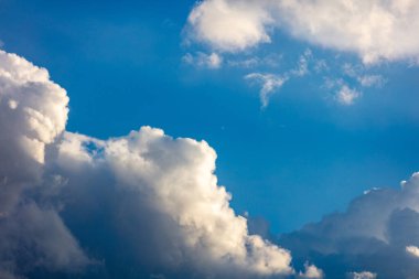 Mavi gökyüzü arka planında ağır kara bulutlar, tüylü kümülüs bulutları, bulutlu manzara beyaz ve gri renk, kasvetli hava