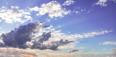 Mavi arka planda gün doğumu renkli bulut. Kümülüs bulutlu beyaz gri renk ve turuncu ton. Gün batımı ışığı bulutlu gökyüzünü renklendirir. Alacakaranlık, şafak vakti