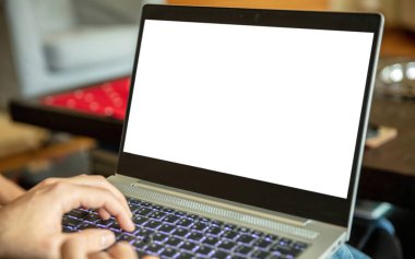 Ev işleri. Boş ekran, dizüstü bilgisayarda yazı yazan bir erkek, bacaklarda açık bir defter, kopyalama alanı, şablon