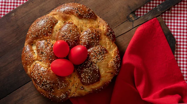 Greek tsoureki, Easter sweet bread, cozonac and red dye egg top view. Braided brioche, festive traditional dessert