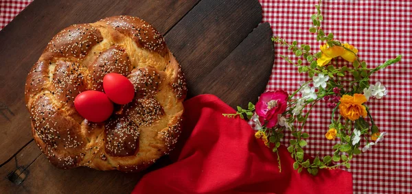 Greek tsoureki, Easter sweet bread, cozonac and red dye egg top view. Braided brioche, festive traditional dessert