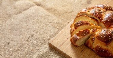 Paskalya tatlı ekmeği, cozonac ya da tsoureki dilimi masaya örülmüş brioche, ahşap üzerinde geleneksel challah, kopyalama alanı