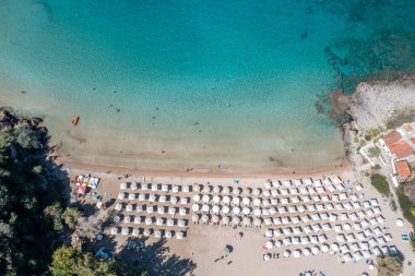 Yunanistan, kumlu plaj, hava aracı manzarası. İnsanlar Stoupa köyü Mani, Messenia, Moreloponnese yakınlarındaki Kalogria plajında yüzüyor ve dinleniyorlar. Güneşli yaz günü, seyahat yeri