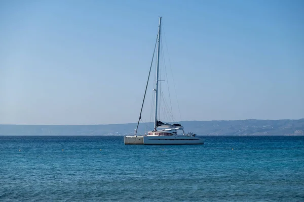 Ιστιοπλοϊκό Καταμαράν Αγκυροβολημένο Κυματιστή Θάλασσα Στεριά Και Γαλάζιο Ουρανό Καλοκαιρινές — Φωτογραφία Αρχείου