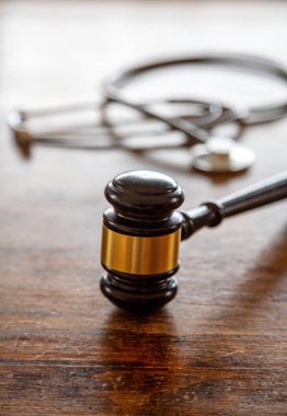 Kişisel yaralanma avukatı. Yargıç Gavin ve doktor steteskop avukat masasında. Sağlık ve Hukuk kavramı. Tıbbi hata, hukuki açıdan...