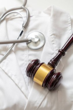 Sağlık ve Hukuk. Yanlış tedavi, kişisel yaralanma avukatı. Yargıç Tokmak ve steteskop doktor ceketinde.
