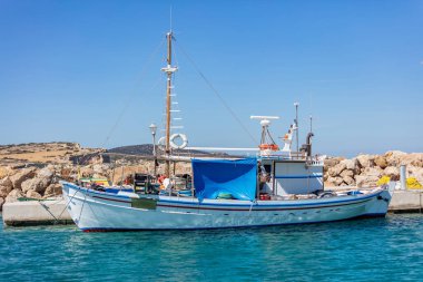 Yunanistan. Koufonisi Yunan adası Kiklades 'teki kayalık inşaat iskelesine demirlemiş ahşap balıkçı teknesi. Ege sakin denizi, mavi gökyüzü