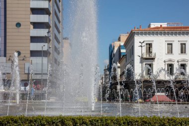 Omonoia Meydanı 'ndaki çeşme, Atina, Yunanistan. Güneşli bir gün, mavi gökyüzü. Omonia şehir merkezinde yuvarlak bir plazadır.
