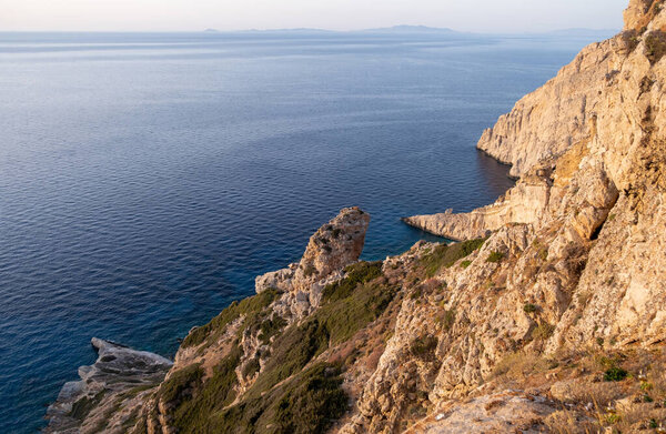 Folegandros island. Cyclades, Greece. Breathtaking view over the Aegean sea from high cliffs. Calm rippled sea water, blue sky, sunny day