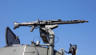 Zırhlı personel taşıyıcı taretindeki makineli tüfek, askeri geçit töreni. Savaş ağır silahları, mavi gökyüzü geçmişi. Savaş ve savunma için ordu ekipmanları.