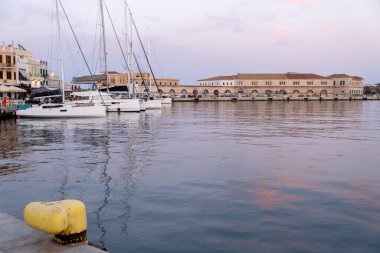 Ermoupolis 'in Siros adasının başkenti Cyclades, Yunanistan. Limanı demirli yat, rıhtım binası, deniz yansıması, renkli gökyüzü arka planı..