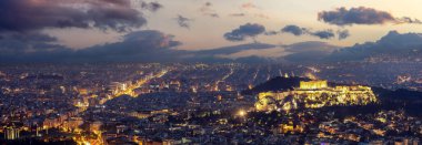Atina, Yunanistan. Akropolis ve Parthenon tapınağı gece aydınlandı. Eski kalıntılar, Lycabettus Tepesi 'nin havadan manzarası. Şehir manzarası ve şehrin ışıkları alacakaranlıkta