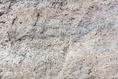 Grey rock shaped by the sea, salt and wind background texture. Stone formation, rough mineral material. Abstract natural rocky surface. Greek island Greece.