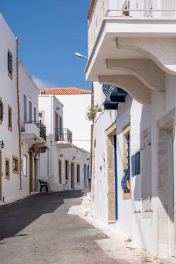 Yunanistan, Kythira Adası. Chora kasabasında boş dar bir sokak. Geleneksel evler ve kapalı dükkanlar beyaz renkli duvarlar, mavi rüzgarlar ve kapı