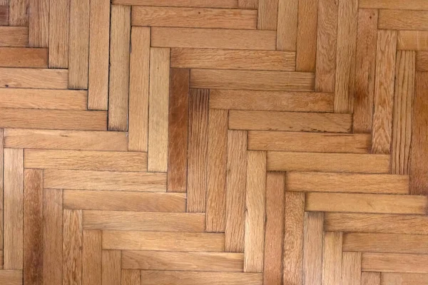 Herringbone natural parquet wood floor texture. Wooden oak flooring background. Old brown decorative plank, repeated pattern. House interior, top view