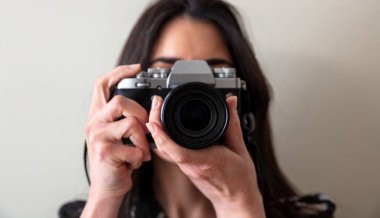 Elinde fotoğraf makinesi olan genç bir kadın senin fotoğrafını çekiyor. Kız fotoğrafçı sana odaklan, manzarayı kapat.