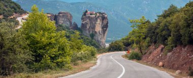 Meteora Yunanistan. Vadideki asfalt yolda. Rousanos 'un kutsal manastırı kayanın üstündeki Saint Barbara binaları., 