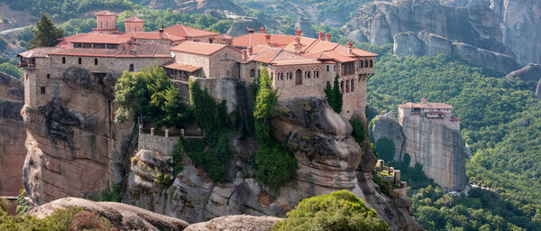 Метеора Греция. Варлаамский Святой монастырь и здания на вершине скал, вид сверху. Также вид на монастырь Русанос. Европа религия путешествия
