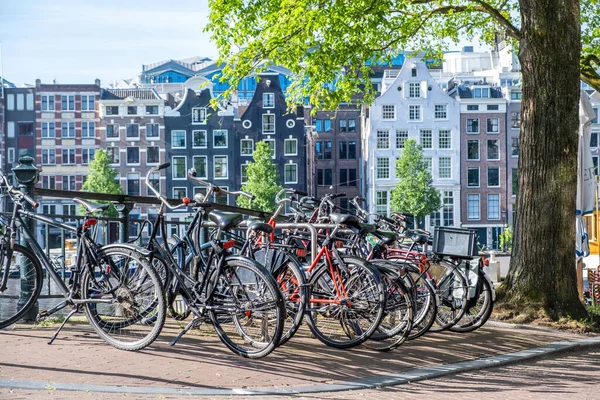 Fietsen Geparkeerd Een Grachtbrug Amsterdam Traditionele Bakstenen Gevel Huizen Achtergrond — Stockfoto