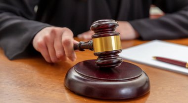 Açık arttırma hukuku tokmağı tutan bir kadın. Elinde not defteri olan bir kadın yargıç tahta bir tokmağı dövüyor..