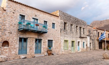 Greece. Areopoli village, Mani Laconia, Peloponnese. Traditional building, empty paved street, historic square. Statue there where Greek revolution against Turk took place on March 17, 1821. clipart