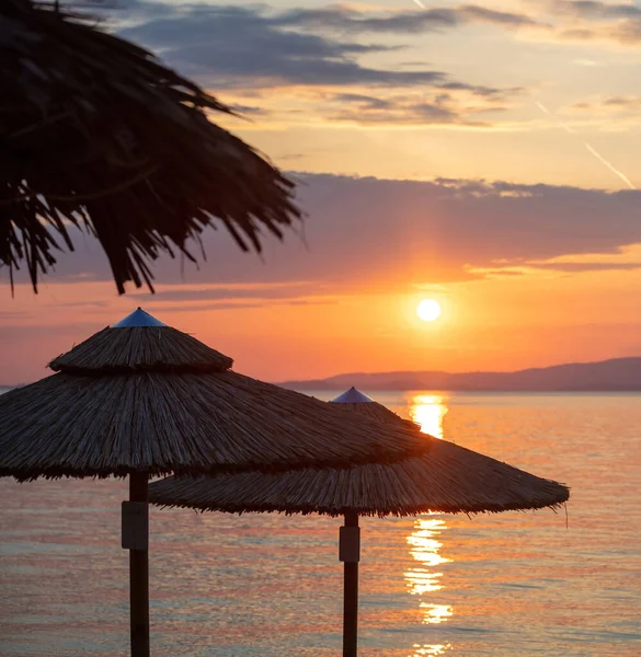 Naplemente Égei Tenger Partján Görögországban Szalma Esernyők Sziluett Arany Tükröződések — Stock Fotó