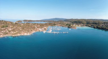 Sithonia Chalkidiki, Yunanistan. Ormos Panagias Körfezi ve yat marinası hava aracı manzarası, açık mavi gökyüzü, güneşli yaz günü.