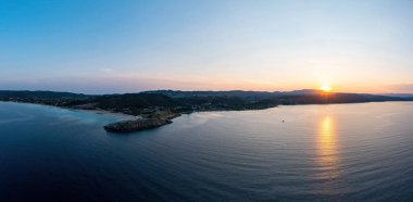 Sithonia Chalkidiki, Yunanistan. Sakin okyanus üzerinde gün doğumu drone görüntüsü. Ormos Panagias 'ta dramatik gün batımı manzarası. Turuncu ve mavi renk gökyüzünü gölgeliyor.
