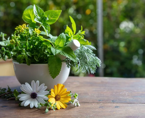 Mint, rosemary, basil and thyme aromatic leaves, Fresh herbs in a mortar on a wooden table, copy space. Herbal medicine, alternative healing.