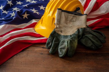 Labor day. Construction helmet and USA Flag on wood, top view. US holiday celebration