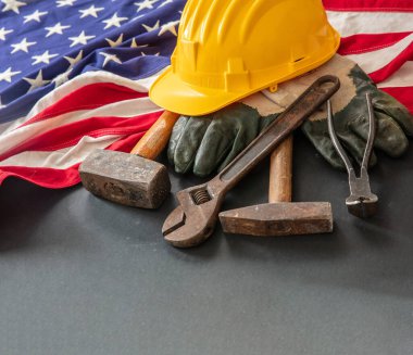 Labor Day concept. American flag and construction tools on dark background, above view. Federal USA holiday celebration