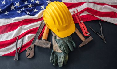 Labor Day concept. American flag and construction tools on dark background, above view. USA holiday celebration