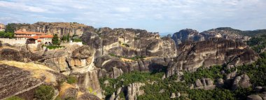 Meteora Greece rocky landscape. Holy Trinity Agia Trias Monastery. Blue sky over buildings on top of rocks. Europe travel destination