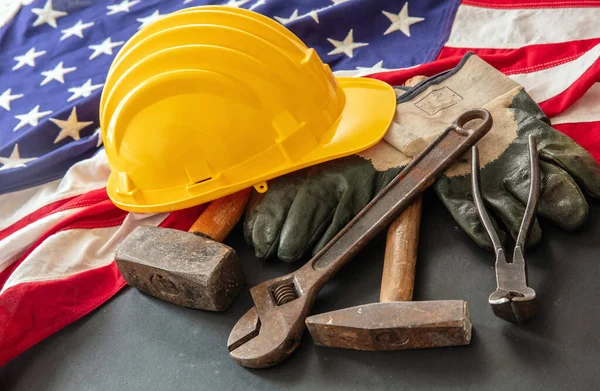 Labor Day concept. American flag and construction tools on dark background, above view. USA holiday celebration