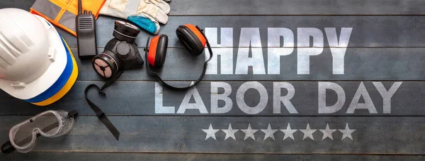 Happy Labor Day text and construction tools on wooden table, top view. United States America holiday celebration, banner