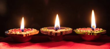 Deepavali Diwali. Hindu festival of lights. Clay diyas candles. Oil lamps lit on dark background, copy space.