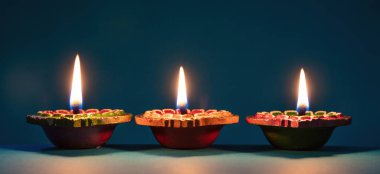 Deepavali Diwali. Hindu festival of lights. Clay diyas candles. Oil lamps lit on dark background, copy space.