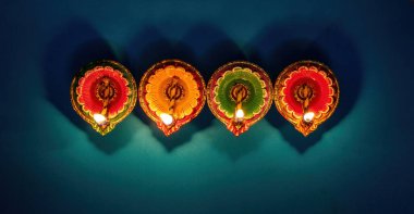Diwali, Deepavali Hindu Festival of lights celebration. Diya oil lamp lit on blue background, top view.