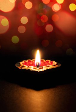 Happy Diwali. Diya lamp lit, colorful rangoli, dark bokeh light background. Deepavali Hindu Festival of lights celebration