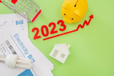 2023 yıl, yaşam masrafları, bakkaliye ve gıda fiyatlarının yükselmesi, tasarruf. Alışveriş arabası domuz kumbarası ve kırmızı ok..