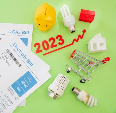 Yaşam maliyeti artışı, 2023 'teki ekonomik kriz düzleşmişti. Alışveriş arabası faturaları ve yeşil arka planda yükselen kırmızı ok.