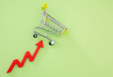 Market fiyatları arttı, gıda fiyatları arttı. Alışveriş arabası ve kırmızı ok. Ekonomik kriz ve enflasyon kavramı.