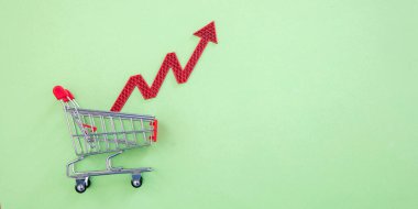 Market fiyatları arttı, gıda fiyatları arttı. Alışveriş arabası ve kırmızı ok. Mali kriz ve enflasyon kavramı.