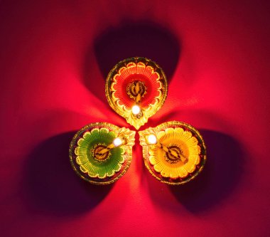 Diwali, Deepavali Hindu Festival of lights celebration. Diya oil lamp lit on red background, top view.