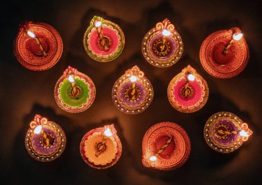 Diwali, Deepavali Hindu Festival of lights celebration. Diya oil lamp lit on black background, top view.
