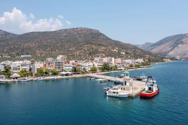 Antikyra Köyü Yunanistan, insansız hava aracı manzaralı. Rıhtım binaları, demirli tekneler, liman feneri, Boeotia 'da güneşli bir gün.
