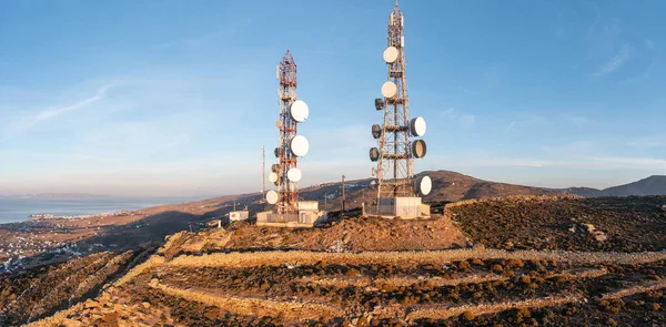 Cell tower. Cellular base station, mobile phone antenna aerial view. 5G radio network telecom transmitter on hill top. Rural island background