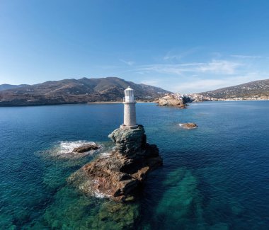 Yunanistan. Andros Adası. Taştan bir işaret kulesinin hava aracı görüntüsü. Chora kasabası pelerini ve kayalık Cyclades manzarası. Mavi gökyüzü ve deniz