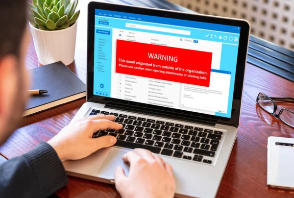 Email attachments warning message on a laptop screen. Computer Virus and Antivirus. Cyber security concept.