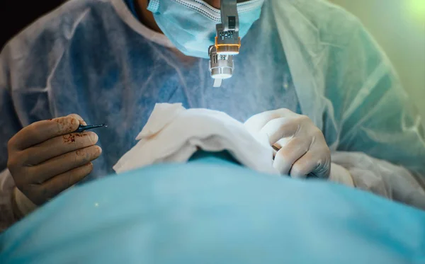 Plastický Chirurg Operuje Pacientem Brýlemi Baterkou Operačním Sále — Stock fotografie